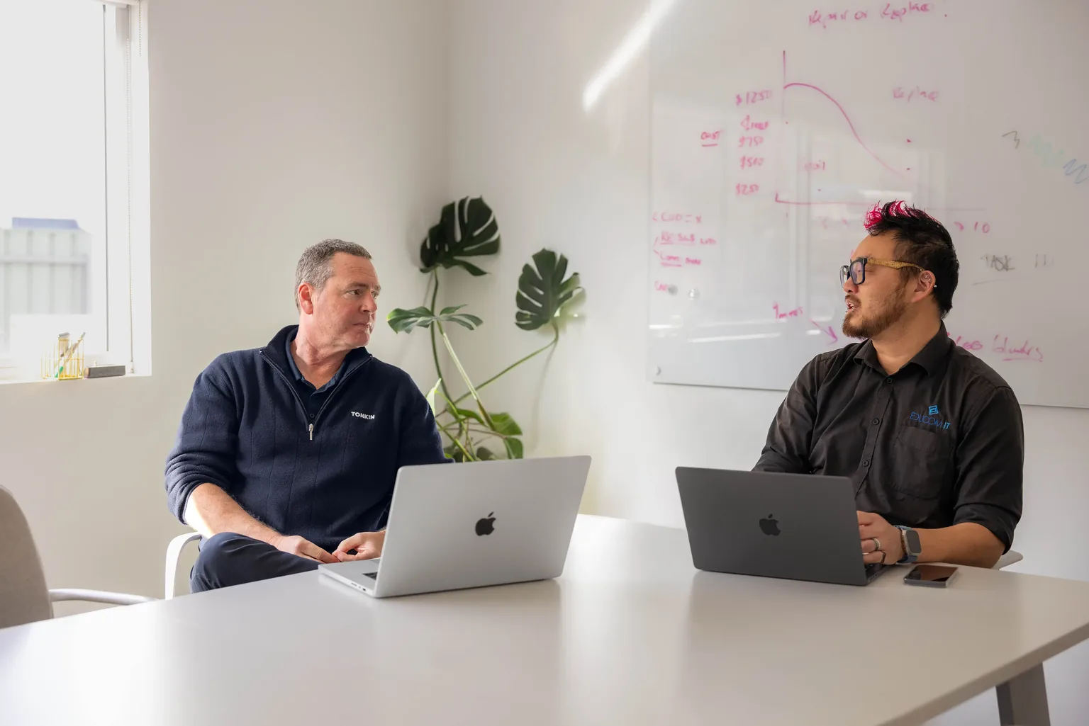 Tonkin and EduCom IT team members planning work together around MacBooks