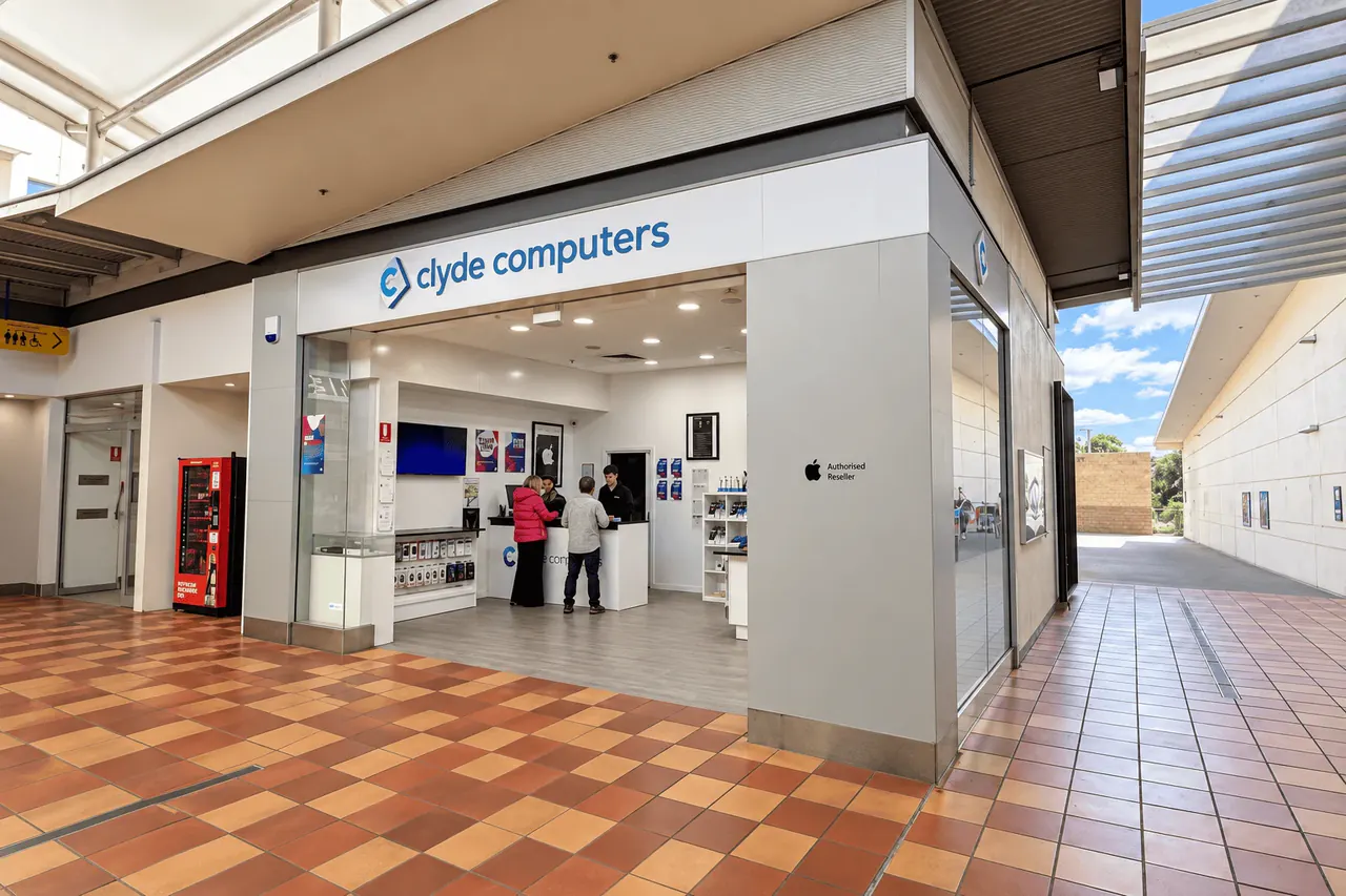 The Clyde Computers store in the Village Centre, Batemans Bay — staff serving customers at the counter under the shopfront sign.